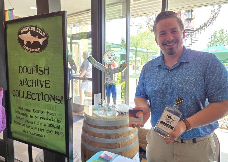 Andrew Campbell, a staff archivist at History Factory, was at Dogfish Head’s Milton brewery recently collecting things from people who wanted to help the company preserve its history. Campbell is holding a large, unopened bottle of hand sanitizer from when Dogfish modified its operations during COVID. CHRIS FLOOD PHOTOS